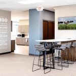 open office with infographic detail on wall, high top table and chairs and tv with agricultural images